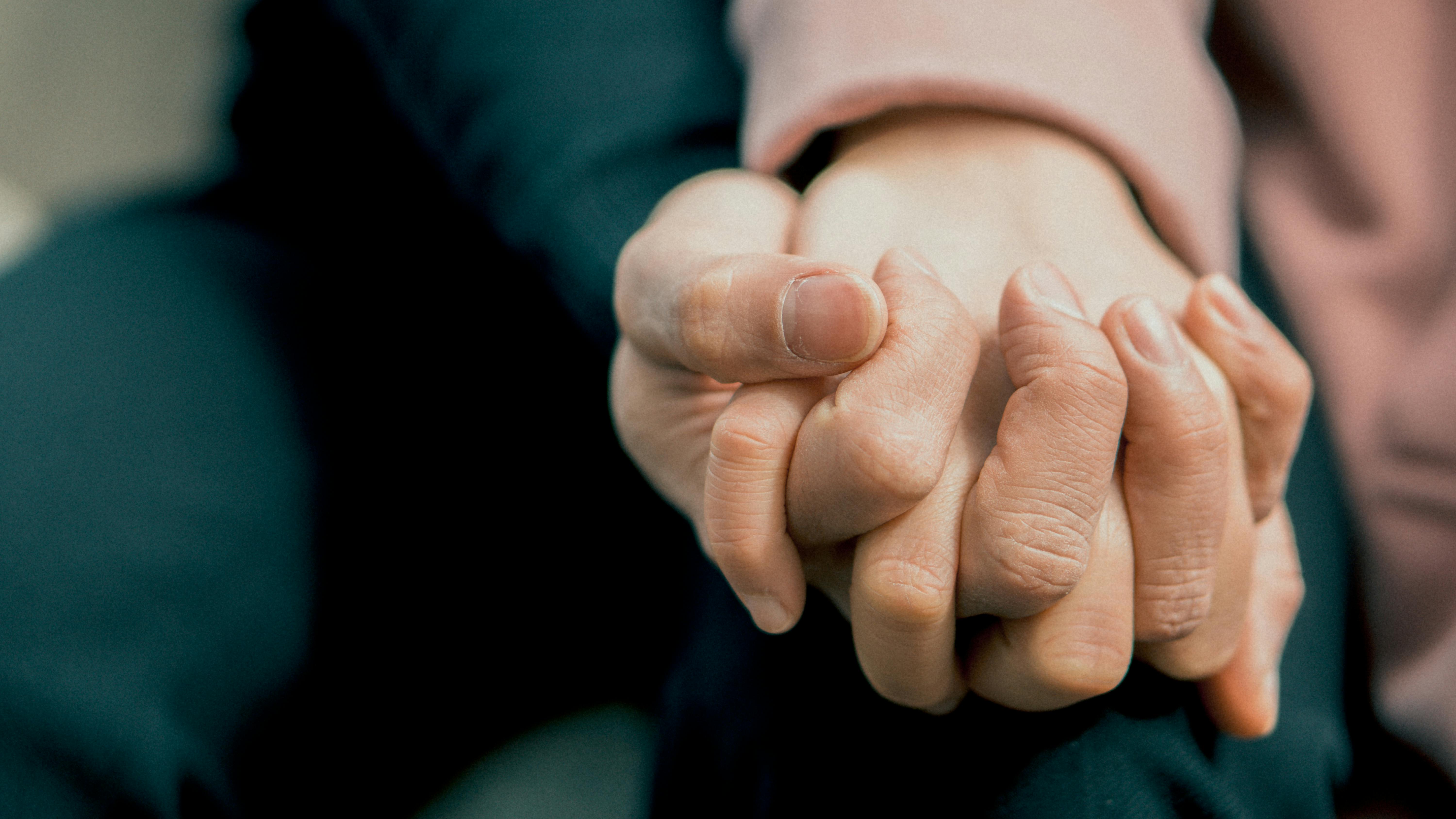 Image of two hands holding each other